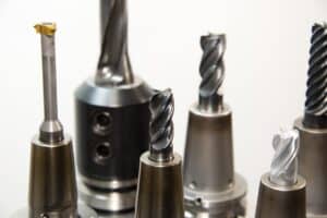 Close-up of various metal cutting tools and drill bits used in industrial manufacturing and machining processes.