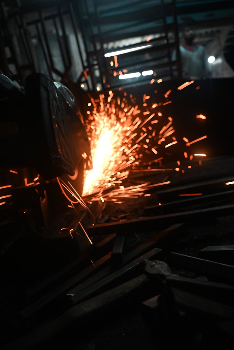 Welder working on a piece of metal in a factory