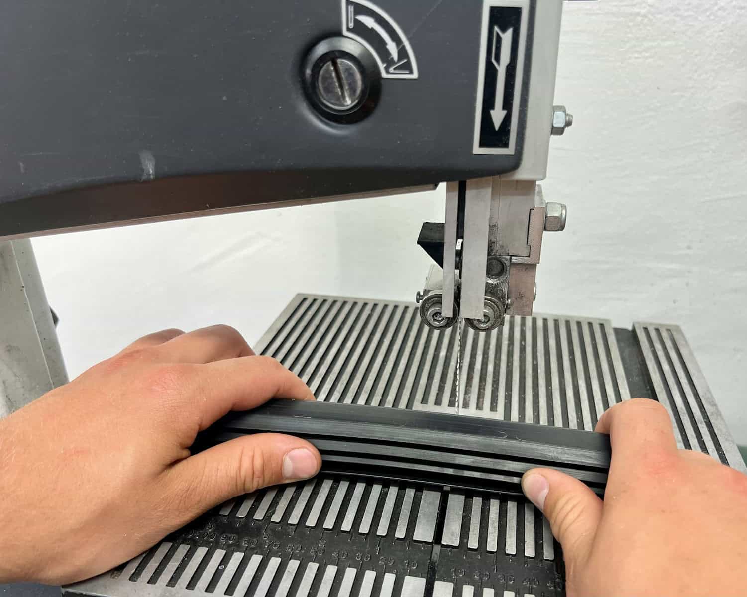 High-precision industrial cutting machine fabricating metal components with manual operator at work.