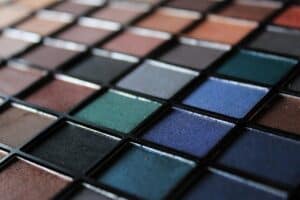 Close-up of a color blending art palette with various shades of paints arranged in a grid pattern, showcasing vibrant and muted tones for creative projects.