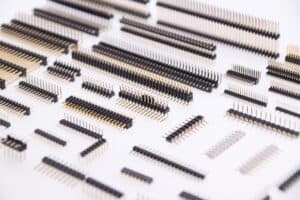 Close-up of various electronic connectors and pins used in industrial and electronic applications, showcasing precision manufacturing and plating techniques.