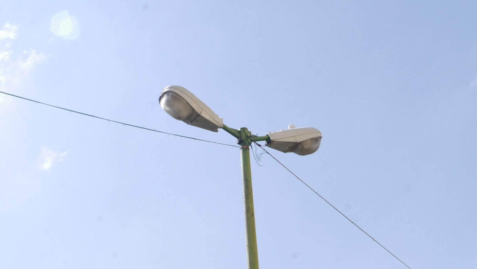 green street light under blue sky during daytime