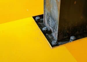 Steel foundation with anchor bolts securing a structure to a concrete surface.