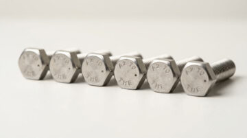 Close-up of high-strength hexagon bolts with threaded ends, used in industrial machinery and construction.