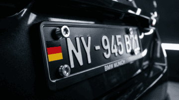 Close-up of a German license plate on a BMW vehicle, highlighting precision and durability, representing high standards in industrial screw manufacturing.