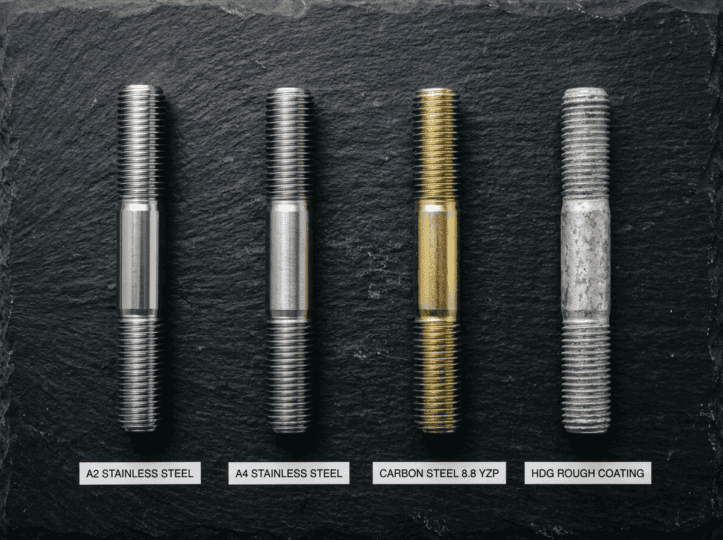 Close-up of four industrial bolts made from stainless steel, carbon steel, and with rough coating, showcasing various finishes and sizes for industrial applications.