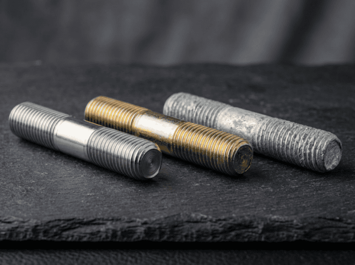 Three different types of steel flange bolts with threaded shafts displayed on a dark surface, showcasing their durability and precision for industrial fastening needs.