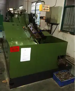 Automatic screw making machine producing industrial metal fasteners in DingLong Hardware workshop