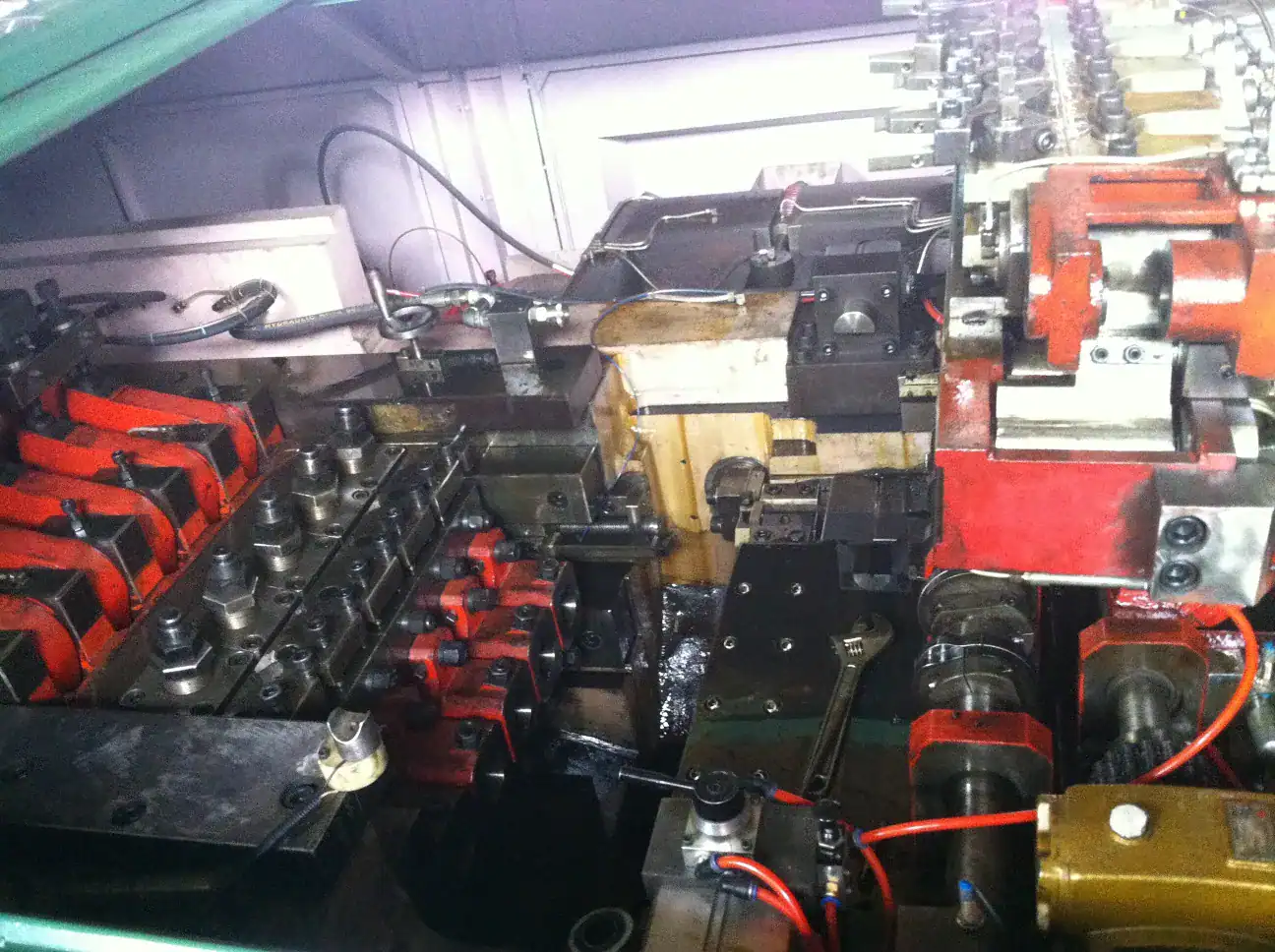 Close-up of fastener forming machine components for screw processing and thread preparation